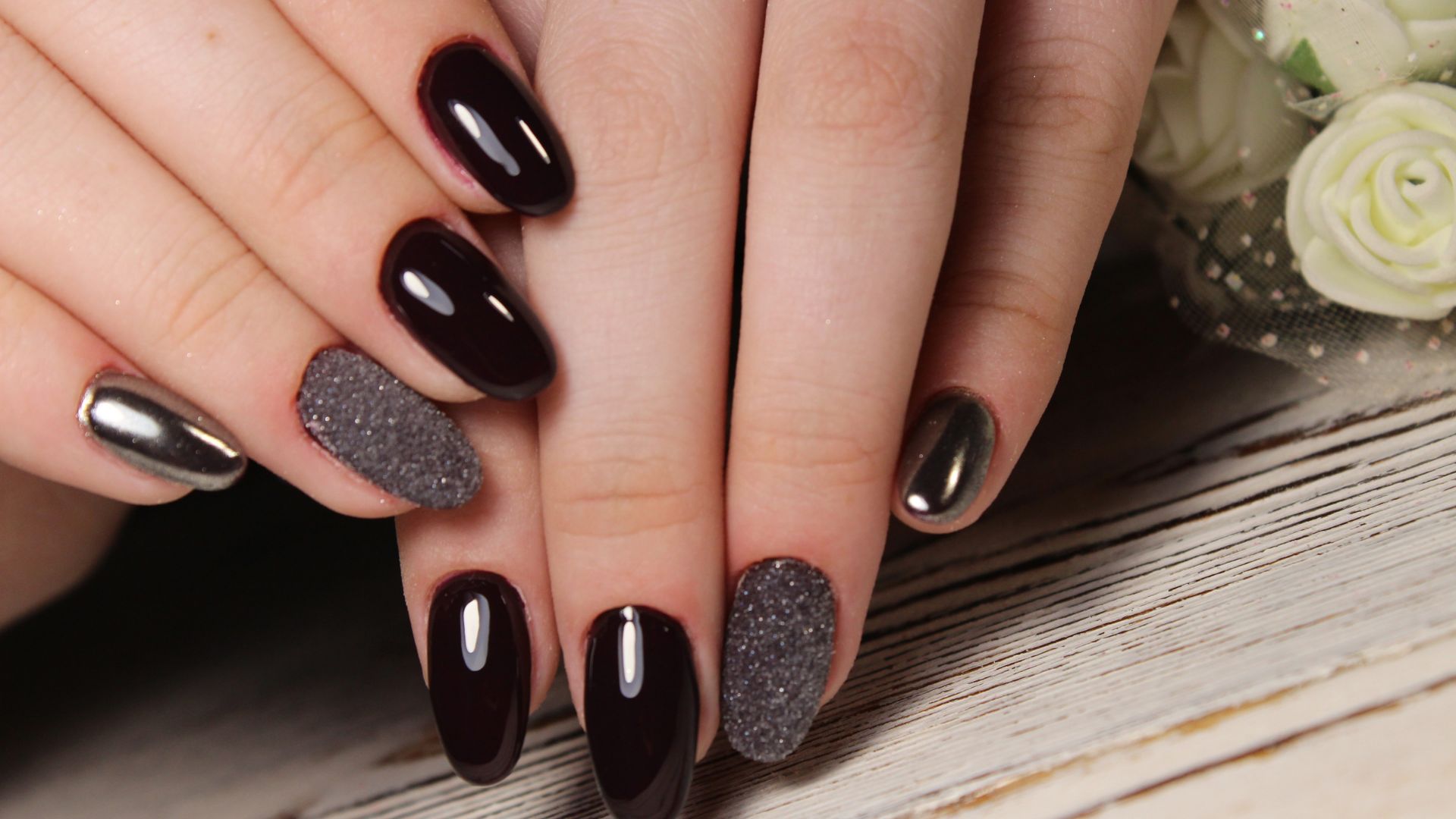 Nageldesign in Dunkelrot mit Chrom- und Glitzer-Akzenten
